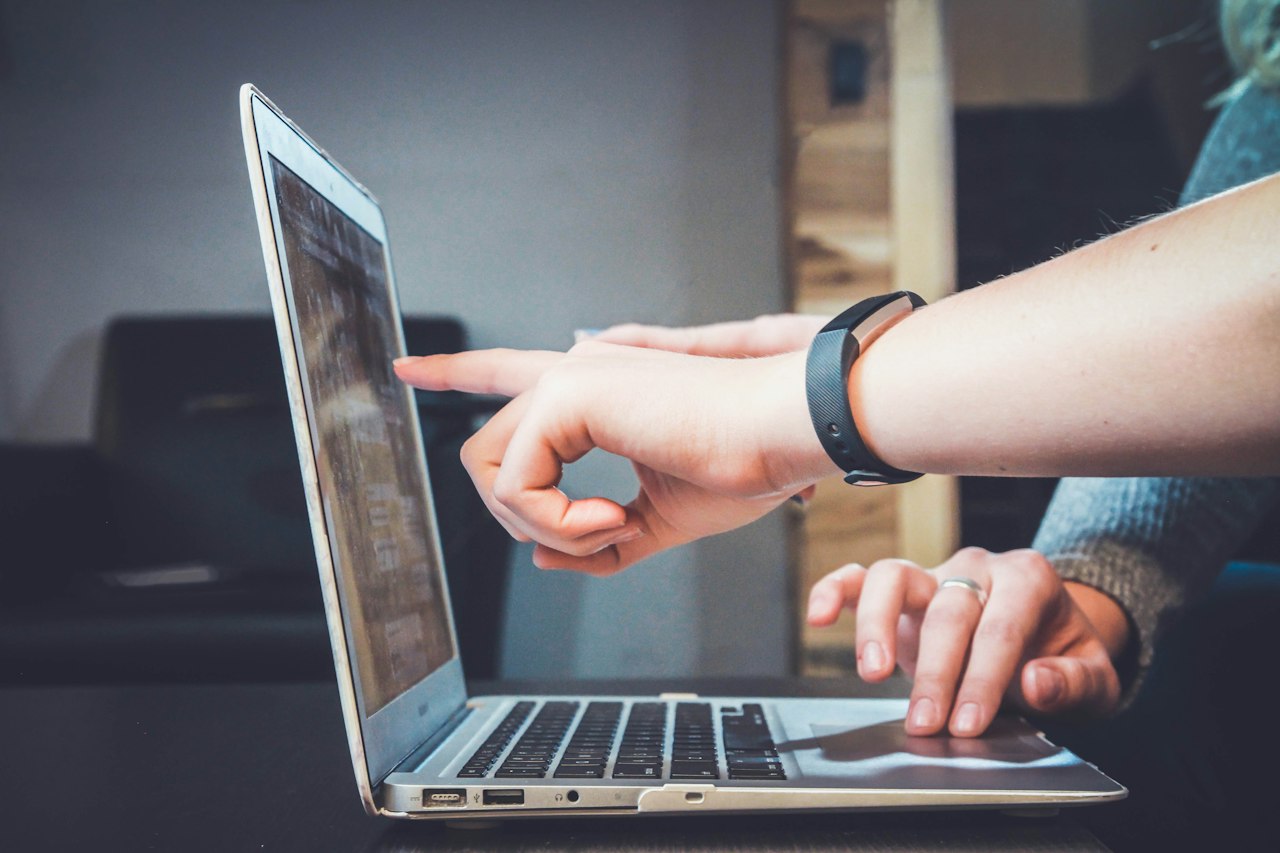 Hands using a laptop and phone together