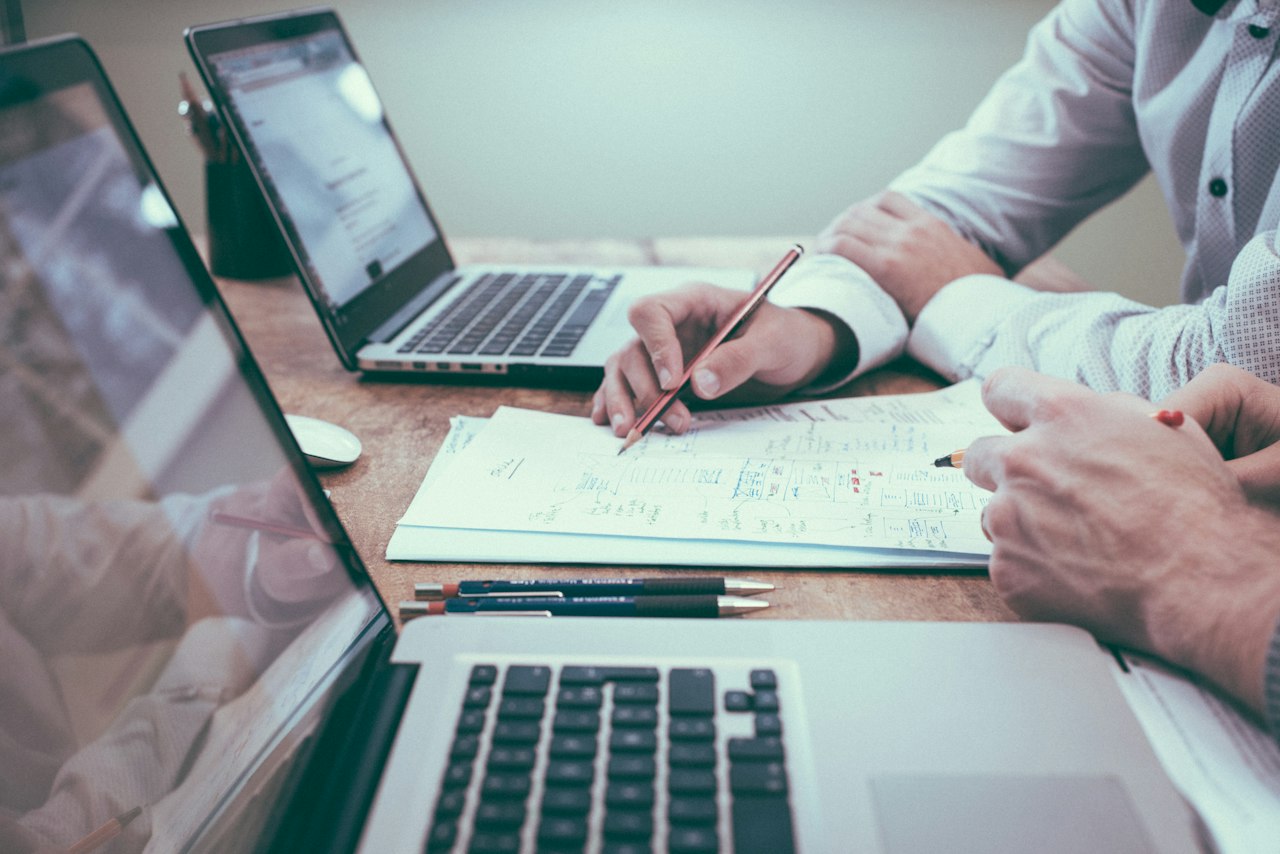 Person working with documents and a laptop at a desk
