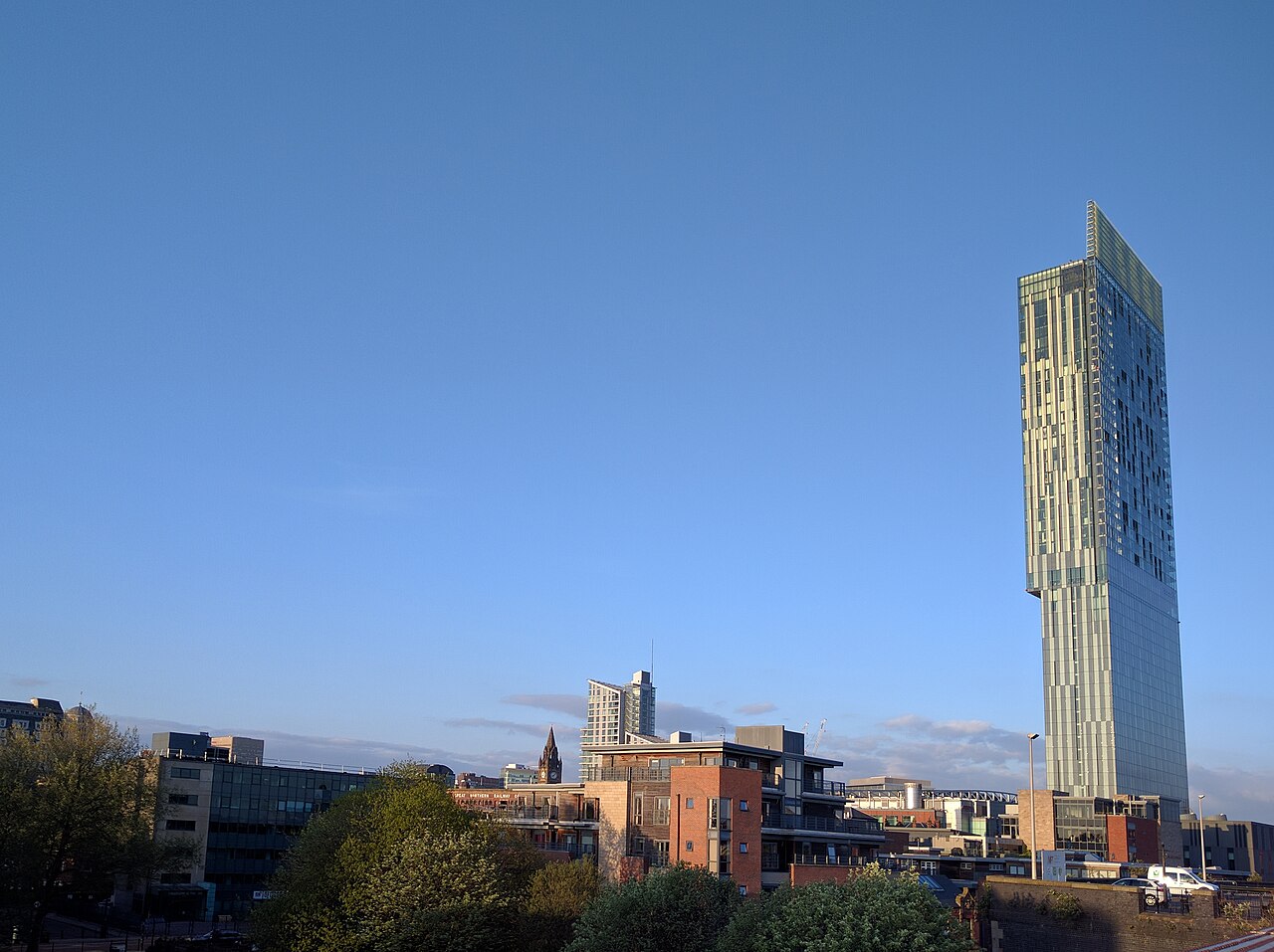 Beetham Tower, a glass slab with a cantilevered top, against a clear blue sky